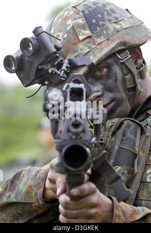 (dpa) - An infantryman of the Bundeswehr (German army) aims with his 40mm granade gun during a photo opportunity at the military infantry school in Hammelburg, Germany, 1 July 2004. The Bundeswehr will be equiped with new armaments and materials for an improved military response in future deployments which include new high-tech bulletproof vest, better protection from NBC weapons,  Stock Photo