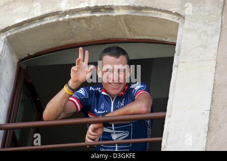 (dpa) - On the Tour de France's last off day, five time Tour winner Lance Armstrong of team US Postal waves from his hotel room in St-Paul-Trois-Chateaux, France, 19 July 2004. Before the decisive stages of the cycling race in the Alpes, Armstrong trails the leader, Frenchman Thomas Voeckler, by only 22 seconds. Stock Photo