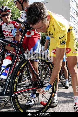 (dpa) - French cyclist Thomas Voeckler, wearing the yellow jersey of the overall leader, of team Brioches La Boulangere inspects his bicycle prior to the start of the 10th stage of the Tour de France cycle race in Limoges, France, 14 July 2004. The first mountainous stage of the Tour leads through the Massif Central from Limoges to Saint-Flour. With 237 km it is also the longest st Stock Photo