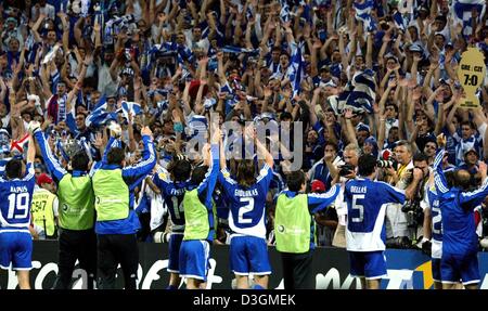 (dpa) - The players of the Greek national soccer team turn to their fans jump up, cheer and jubilate after the final whistle of the Soccer Euro 2004 semifinal opposing Greece and the Czech Republic  in Porto, Portugal, 1 July 2004. One supporter (R) holds up a plate in the shape of a trophy displaying a 7-0 goal result. Greece won with a 1-0 silver goal during extra time in the 105 Stock Photo