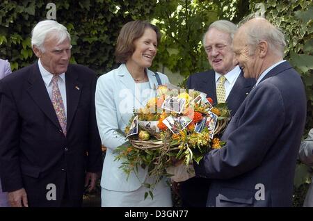 (dpa) - Reinhard Schlagintweit (R), head of UNICEF  in Germany, hands a bunch of flowers to Christina Rau (2nd from L), wife of the German President Johannes Rau (2nd from R), while next to German actor Joachim Fuchsberger in Berlin, 22 June 2004. The United Nations Children Fund officially bid farewell to Mrs Rau and thanked her for her long standing involvement as a patron and sp Stock Photo