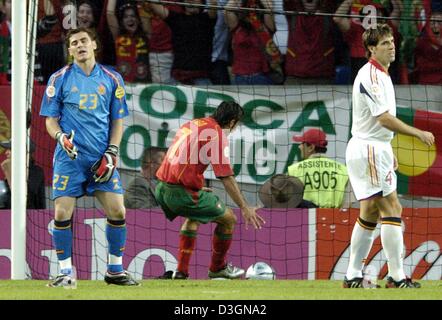 (dpa) - As Portugal midfielder and team captain Luis Figo happily grabs the ball out of the net, his Spanish opponents David Albelda (R) and goalkeeper Iker Casillas look frustrated after Portugal has taken the lead in the Euro 2004 group A match between rivals Spain and Portugal at Jose Alvalade Stadium in Lisbon, Portugal, 20 June 2004. Portugal advanced to the quarterfinals with Stock Photo