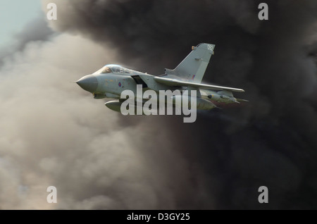 Royal Air Force Panavia Tornado GR4 jet fighter plane taking part in an airshow role demo with pyrotechnics. Explosion smoke