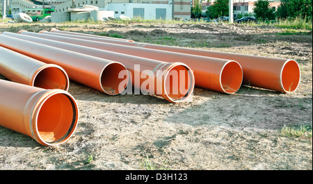 Several orange plastic pipes used in construction for drainage or the sewerage on a building site Stock Photo