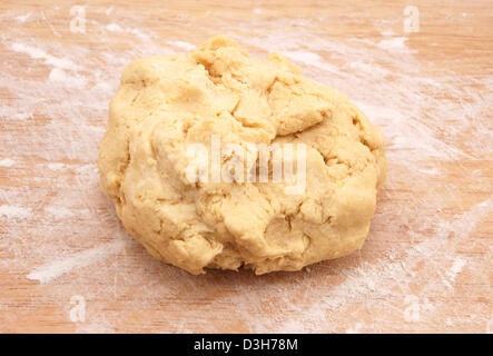 Fresh ball of pastry ready to be rolled out on a floured wooden board Stock Photo