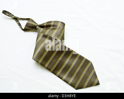 A rolled up striped yellow and black tie isolated on white background. Stock Photo