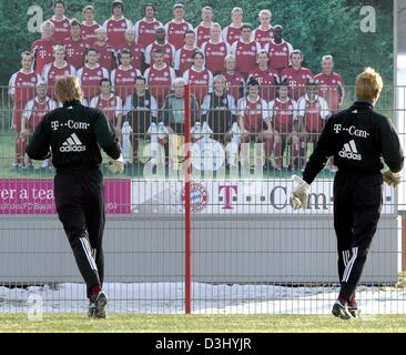 (dpa) - Bayern Munich's goalkeeper Oliver Kahn and substitute goalkeeper Michael Rensing walk acorss the pitch past a team picture of the German soccer club FC Bayern Munich in Munich, Germany, 22 January 2004. The second half of the Bundesliga season starts on 31 January 2004. Bayern Munich will play against soccer club Eintracht Frankfurt. Stock Photo