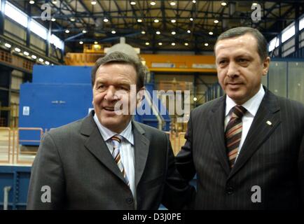 (dpa) - German Chancellor Gerhard Schroeder (L) and Turkish Prime Minister Recep Tayyip Erdogan pose in the turbine hall of the mineral coal power plant in Iskenderun, Turkey, 24 February 2004. The ISKEN power plant, which was built by German companies, was opened during Schroeder's visit. Schroeder is on an three-day official visit to Turkey. Stock Photo