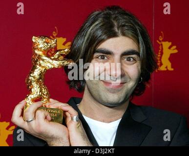 (dpa) - German director Fatih Akin smiles as he poses with the 'Golden Bear' trophy in his hands at the end of the 54th Berlinale International Film Festival in Berlin, 14 February 2004. Akin was awarded for his film 'Gegen die Wand' (Against the Wall) which was the first time since 1986 that a film from Germany was awarded the 'Golden Bear'. The film tells the story of a young Tur Stock Photo