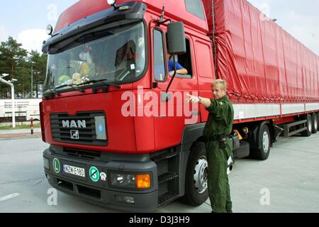 (dpa) - An officer of the German border police indicates to a lorry driver the way to the custom controls hall for lorries, where the papers and technical condition of the vehicles are checked, at the German-Polish border in Forst, Germany, 19 August 2003. Stock Photo