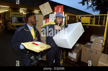 (dpa) - Two DHL parcel deliverers prepare their itinerary at the logistics centre in Dortmund, Germany, 21 October 2003. DHL is the worldwide parcel, express and logistics services branch of the Deutsche Post group. Stock Photo