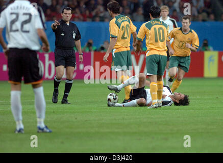 Michael Ballack (L) of Germany is on the ground when he is ...