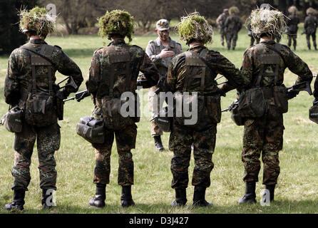 (dpa file) -  A group of conscript of the armoured infantry division of the German Bundeswehr, dressed in camouflage and armed with a G36 rifle, stand on a field during a field exercise as part of the basic military training at the Knuell Barracks in Schwarzenborn, Germany, 14 April 2005. Stock Photo