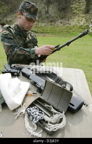 (dpa file) - A conscript of the German Bundeswehr takes apart and ...