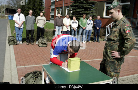 (dpa) - Conscipts in civilian clothes sign in to a list on a table before dressing at the Knuell barracks in Schwarzenborn, Germany, 4 April 2005.