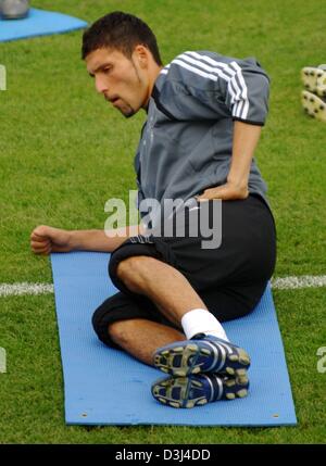 (dpa) - VFB Stuttgart's soccer player Kevin Kuranyi lies on a gymnastics mat and conducts a stretching exercise during a practice sessions of the German national soccer team at the soccer stadium in Frankfurt, Germany, Sunday, 12 June 2005. Kuranyi signed a seven million contract with Bundesliga soccer club FC Schalke 04 running until 2010. The German team prepared to play against  Stock Photo