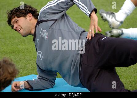 (dpa) - VFB Stuttgart's soccer player Kevin Kuranyi lies on a gymnastics mat and conducts a stretching exercise during a practice sessions of the German national soccer team at the soccer stadium in Frankfurt, Germany, Sunday, 12 June 2005. After a two-week lasting workout and a three-day vacation the soccer ball was again the centre of the team's attention. The German team prepare Stock Photo