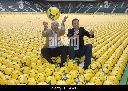 (dpa) - Franz Beckenbauer, President of the organising committee for the 2006 soccer World Cup and Oliver Bierhoff (R), manager of the German national soccer team (DFB team), sit next to each other amidst 142,000 soccer balls at the Borussia-Park stadium in Moenchengladbach, Germany, Monday, 06 June 2005. The balls, which display the logo of the world cup sponsor 'Postbank', are go Stock Photo