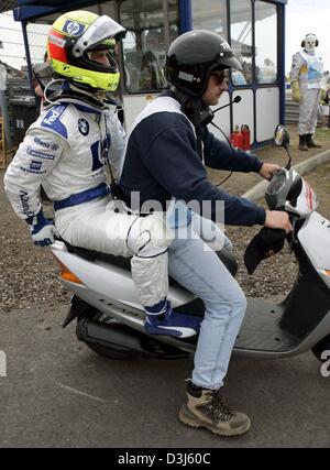 (dpa) - German formula one pilot Ralf Schumacher (BMW-Williams) is driven back to the paddocks by a track marshall following his accident during the European Grand Prix at the Nuerburgring race track in Germany, 30 May 2004. Stock Photo