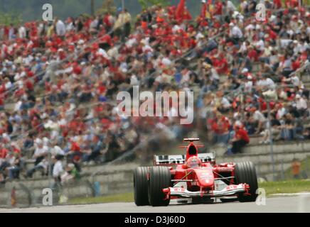 (dpa) - German formula one world champion Michael Schumacher (Ferrari) drives past the grandstands during the European Grand Prix at the Nuerburgring race track in Germany, 30 May 2004. Michael Schumacher won the race. Stock Photo