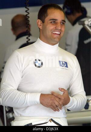(dpa) - Colombian formula one pilot  Juan Pablo Montoya of BMW-Williams smiles as he stands in the pit during the free training at the Nuerburgring race track in Germany, Friday 28 May 2004. The European Grand Prix takes place at the Nuerburgring on 30 May 2004. Stock Photo