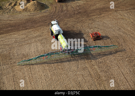 aerial view of an agricultural crop spaying boom being towed by a tractor Stock Photo