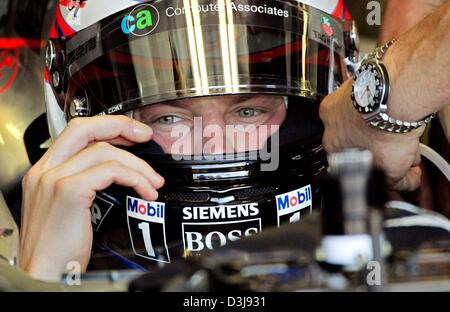 (dpa) - Finnish formula one pilot Kimi Raeikkoenen of McLaren Mercedes, puts on his helmet ahead of the free training at the 'Enzo e Dino Ferrari' racing circuit in Imola, Italy, Friday, 23 April 2004. Raeikkoenen drove the eighth fastes time. The San Marino grand prix starts on Sunday 25 April 2004. Stock Photo