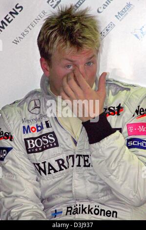 (dpa) - Finnish formula one pilot Kimi Raeikkoenen (McLaren Mercedes) rubs his eye shortly before the start of the free training along the 'Enzo e Dino Ferrari' racing circuit in Imola, Italy, Friday, 23 April 2004. Raeikkoenen drove the eighth fastes time. The San Marino grand prix starts on Sunday 25 April 2004. Stock Photo