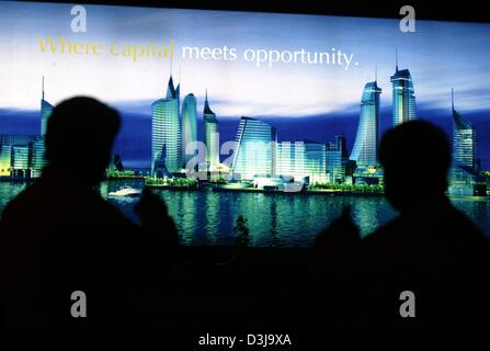 (dpa) - The silhouettes of two men stand in front of an illuminated advertising board for the new financial district ub Manama, Bahrain, 31 March 2004. The first buildings of the district are expected to be completed by 2006 as part of a 820 million euros project which comprises altogether 24 high-rises. The Formula 1 Grand Prix of Bahrain will take place f or the first time this S Stock Photo