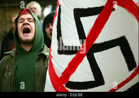 (dpa) - A left-wing supporter calls out as he holds a sign which depicts a crossed out swastica during a protest march against a rally of the right wing extremist party NPD in Dresden, Germany, 13 February 2005. Several hundred neo-Nazis gathered in Dresden on the occasion of the 60th anniversary of the bombing raid on Dresden in order to denounce 'allied war crimes' without refere Stock Photo