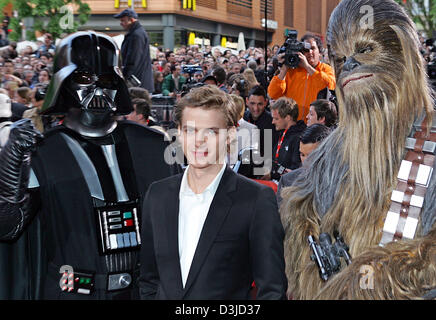 (dpa) - Canadian actor Hayden Christensen (C) stand between two extras dressed as Darth Vader (C) and Chewbacca as he arrives for the premiere of the new 'Star Wars Episode 3 - Revenge of the Sith' in Berlin, 17 May 2005. Hundrets of fans attended the event. The film was officially released worldwide on Thursday, 19 May 2005 and bridges the gap between the first Star Wars film from Stock Photo