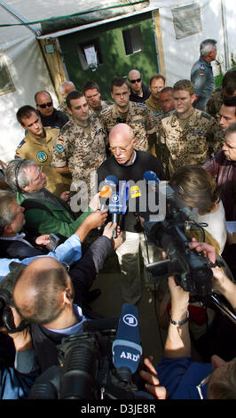 (dpa) - Federal Defence Minister Peter Struck (C) talks to journalists at the airport in Termez, Usbekistan, Wednesday 27 April 2005. Because of bad weather in Kabul (Afghanistan) Struck had to stay overnight until Belgian military was able to fly him out of Kabul. Struck paid visits to the United Arab Emirates, Usbekistan and Afghanistan. Stock Photo