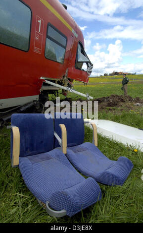 (dpa) - Ripped out seats lie next to a derailed train carriage near Dietmannsried, Germany, Tuesday, 26 April 2005. The train collided with a construction machinery on a railway crossing, causing the train to derail, killing the train driver and leaving 15 passengers injured. Stock Photo