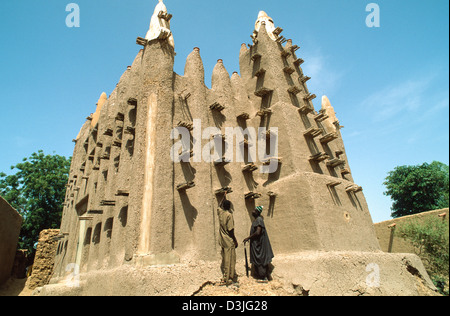 Two men from the Bozo tribe inspecting the traditional adobe mosque in a fishing village on the banks of the R.NIger. Dagua Womina. Mali, West Africa Stock Photo