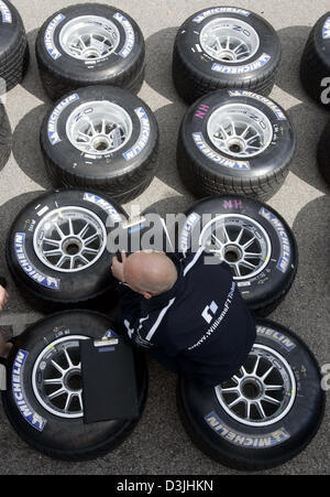 (dpa) - A mechanic of BMW-Williams sits on racing wheels with Michelin tyres in the paddock at the formula one racetrack in Imola, Italy, Thursday 21 April 2005. The Grand Prix of San Marino will start here on Sunday 24 April 2005. Stock Photo