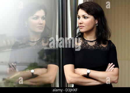 (dpa) - Russian opera singer Anna Netrebko with her arms crossed watches through a window during a press conference in Frankfurt Main, Germany, 18 April 2005. Netrebko (32) performs overall five concerts in Germany, one in Frankfurt, Tuesday 19 April 2005. Stock Photo