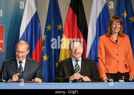(dpa) - German Chancellor Gerhard Schroeder (C), Russian President Vladimir Putin (R) and German Minister of Science Edelgard Bulmahn smile as they sign a declaration for a strategic co-operation in the areas of education, research and innovation at the industrial fair in Hanover, Germany, 11 April 2005. Altogether eight agreements were signed between Germany and Russia in line wit Stock Photo