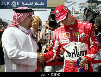 (dpa) - A sheik (L) welcomes German Formula One driver Michael Schumacher (Ferrari) prior to the Grand Prix of Bahrain at the Formula One track near Manama, Bahrain, 3 April 2005. Stock Photo