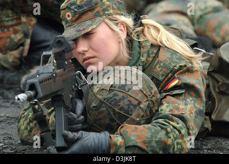 (dpa) - A female recruit of the German Bundeswehr secures with a gun of ...