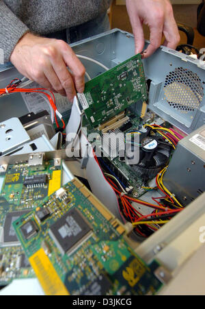 (dpa) - A technician installs a graphics card into a computer's AGP slot in Hamburg, Germany, 28 February 2005. Stock Photo