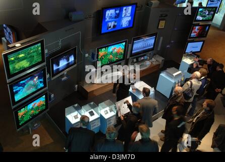 (dpa) - Visitors look at computer screens at the Microsoft stand at the ...