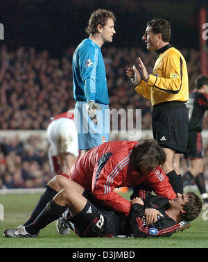 (dpa) - Bayern midfielder Sebastian Deisler (on the pitch) is treated by team physician Hans-Wilhelm Mueller-Wohlfart after a foul while Arsenal goalkeeper Jens Lehmann (L) argues with referee Massimo de Santis (C) during the UEFA Chmapions League match between English side Arsenal London and Germany's Bayern Munich at Highbury Stadium in London, United Kingdom, 9 March 2005. Arsen Stock Photo