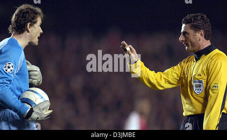 (dpa) - Arsenal goalkeeper Jens Lehmann (L) argues with referee Massimo de Santis during the UEFA Chmapions League match between English side Arsenal London and Germany's Bayern Munich at Highbury Stadium in London, United Kingdom, 9 March 2005. Arsenal won the match 1-0 but was still eliminated 3-2 on aggregate. Stock Photo