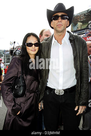 (dpa) - US-born actor Nicolas Cage and his third wife, former waitress Alice Kim, walk over the starting grid before the Grand Prix of Australia, Sunday 06 March 2005 in Melbourne, Australia. Giancarlo Fisichella of Italy won in front of Rubens Barrichello of Brazil and Fernando Alonso of Spain. Stock Photo