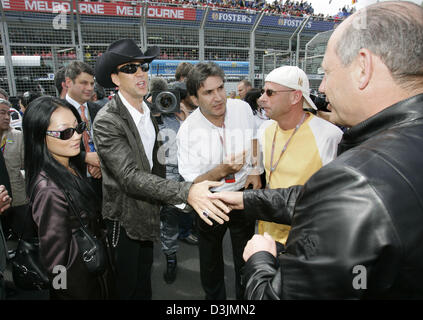 (dpa) - Ron Dennis (R), a FIA official, team leader of McLaren Mercedes and founding president of the Cirque du Soleil Guy Laliberte, welcomes US actor Nicolas Cage (2nd from L) and his third wife, former waitress Alice Kim (L), at the starting grid before the start of the Australian Grand Prix  in Melbourne, Australia, 06 March 2005. Italian formula one pilot Giancarlo Fisichella  Stock Photo