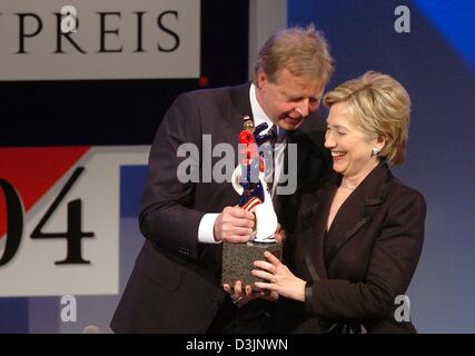 (dpa) - US Senator Hillary Clinton (R) smiles as she receives the German Media Prize 2004 from Karlheinz Koegel, Head of Media Control and founder of of the Media Prize, in Baden-Baden, Germany, 13 February 2005. Clinton was awarded the prize for her exemplary engagement advancing the role of women in the world of politics, society and media. Stock Photo