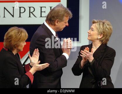 (dpa) - US Senator Hillary Clinton (R) smiles and claps her hands along with  Angela Merkel (L), Chairwoman of the CDU, and Karlheinz Koegel, Head of Media Control and founder of the German Media Prize, in Baden-Baden, Germany, 13 February 2005. 57-year-old Senator Clinton was awarded the German Media Prize 2004 for her exemplary engagement advancing the role of women in the world  Stock Photo