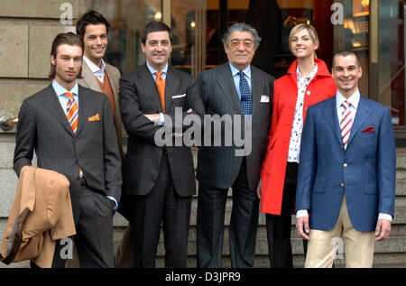 (dpa) - Ciro Paone (C), owner and founder of Italian fashion company Kiton, gives the thumbs up sign while he presents together with Antonio de Matteis (3rd from L), the company's chief financial officer, and models Johann (R), Jana (2nd from R), Guido (2nd from L) and Marcel (L) clothes of the 2005/2006 autumn winter collection prior to a press conference on the occasion of the cp Stock Photo