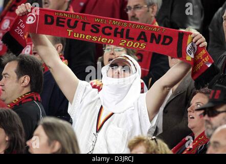 (dpa) - A German handball fan dressed as a sheik holds up a fan-scarf during the German national anthym at the handball world cup match between Germany and Qatar in Sousse, Tunesia on Wednesday 26 January 2005. Stock Photo