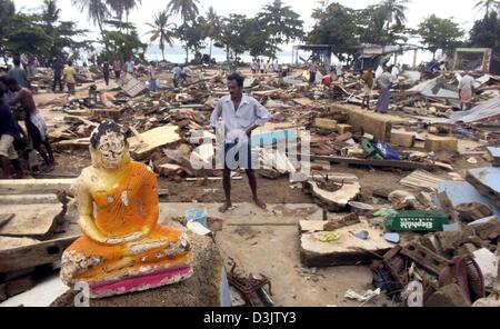 (dpa) - A small damaged Buddha statue stands within debris and rubble in the destroyed city of Galle, Sri Lanka, 29 December 2004. The coast of Sri Lanka was one of the areas most affected by the devastating tsunami that up to now has caused the death of over 150,000 people in southern Asia. There is still a threat of widespread diseases due to destroyed sanitary facilities and unr Stock Photo